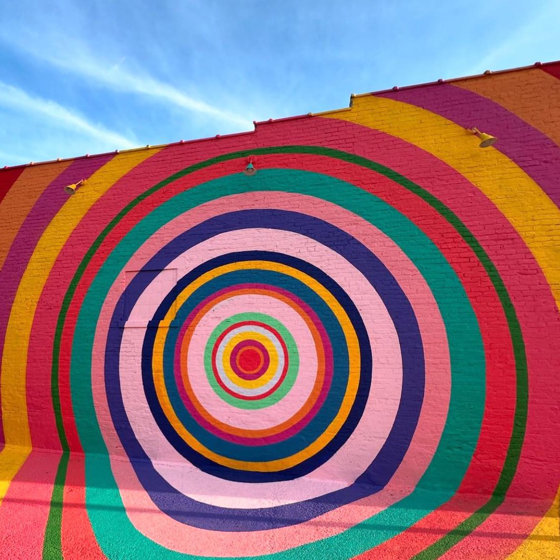 Mark Warren Jacques painting a large radial sunburst mural in his studio